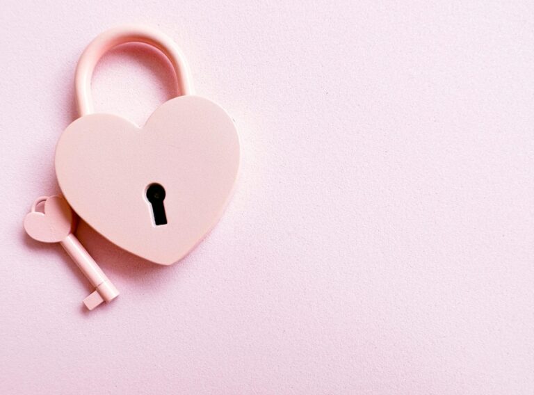 Aesthetic photo of a heart-shaped pink padlock with a matching key on a pink background, perfect for love themes.