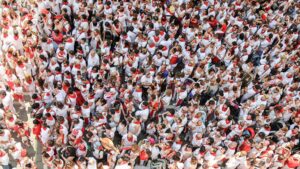 High-angle view of a bustling festival crowd dressed in white and red attire.