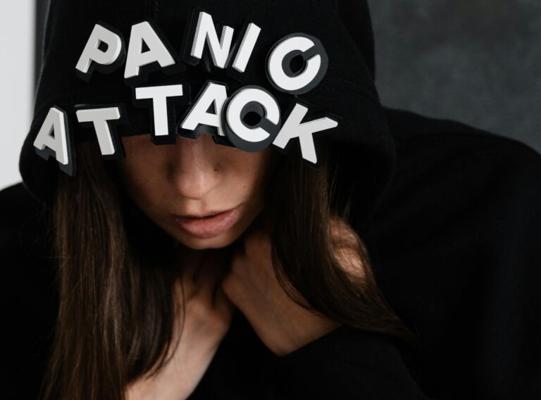 pexels-photo-8410834-8410834 Close-up of a woman in a hoodie with the words 'panic attack', capturing mental health struggles.